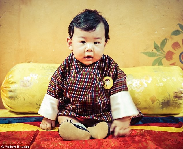 Prince Jigme Namgyal Wangchuck wore a traditional checked robe with cream sleeved and a badge with his father's image for the portraits taken by his dad